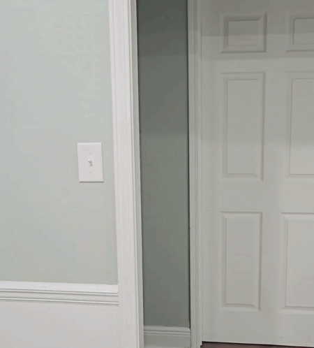 Man in White Shirt Peeking Out of Doorway