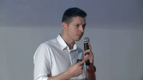 Man in White Shirt Pointing at Microphone
