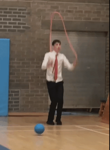 Man in White Shirt Red Tie Kicking Blue Ball