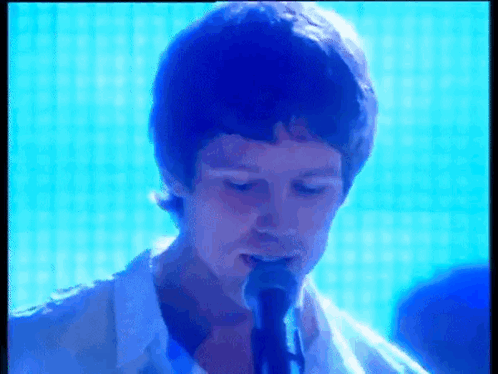 Man in White Shirt Singing into Microphone