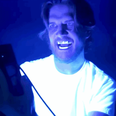 Man in White Shirt Smiling Blue Background