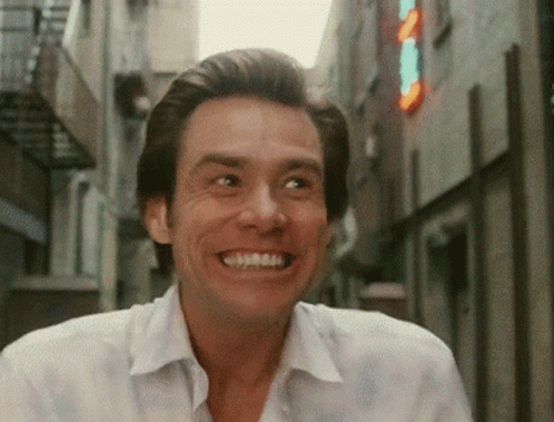 Man in White Shirt Smiling by Sign A in Alley