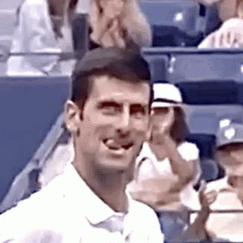 Man in White Shirt Smiling in Stadium