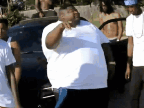 Man In White Shirt Standing Before Group GIF