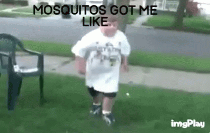 Man in White Shirt Standing in Grass Saying Mosquitos Got Me Like