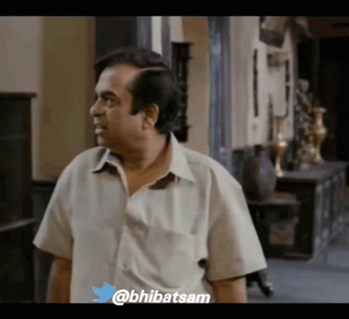 Man In White Shirt Standing In Hallway GIF