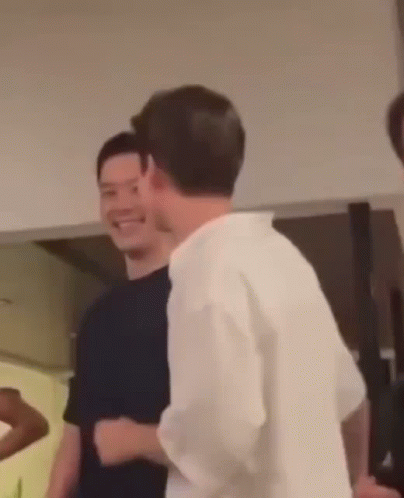Man in White Shirt Standing Next to Man in Black Shirt