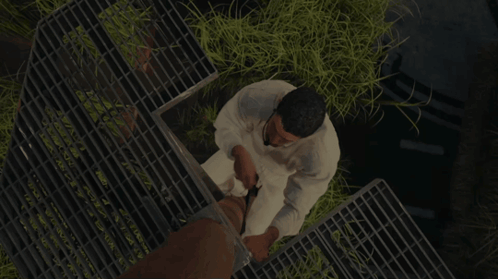 Man in White Shirt Standing on Metal Grid