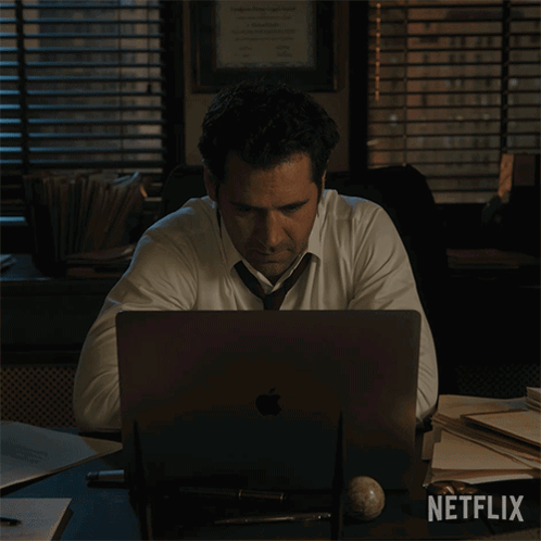 Man in White Shirt Tie at Desk Netflix Logo