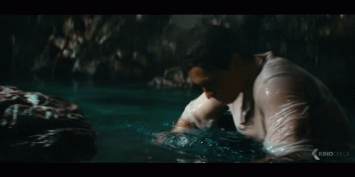 Man in White Shirt Touching Rock in Water