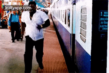 Man In White Shirt Walking Towards Train GIF