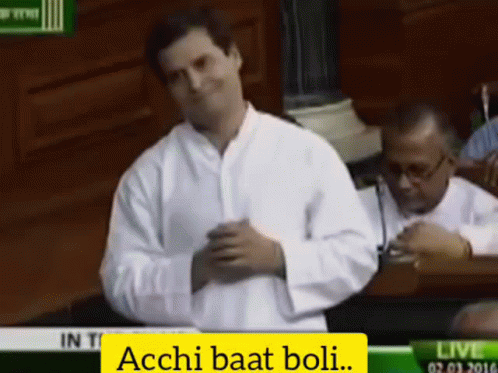 Man in White Shirt With Acchi Baat Boli on Screen