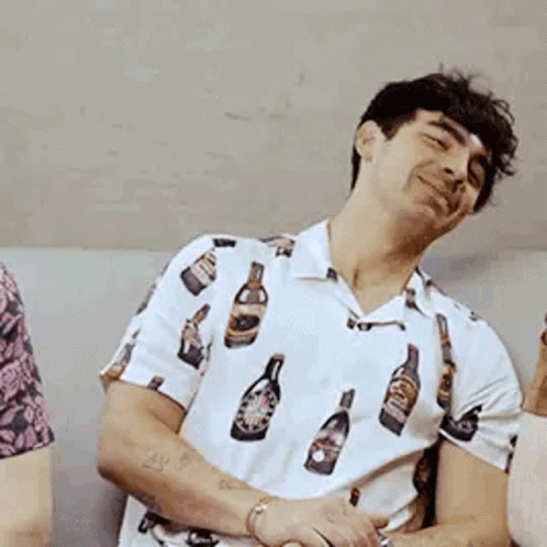 Man In White Shirt With Bottles Sitting On Couch GIF