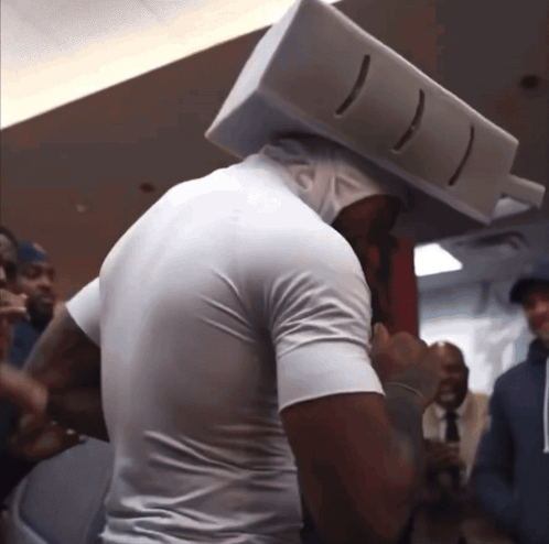 Man in White Shirt With Box on Head