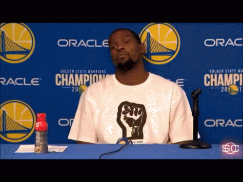 Man In White Shirt With Fist Sitting GIF