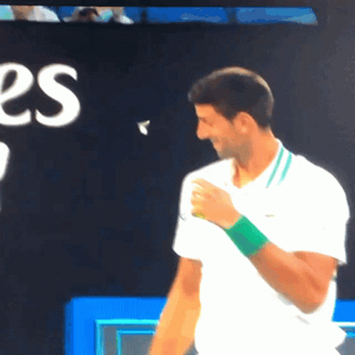 Man in White Shirt With Green Wristband Smiling