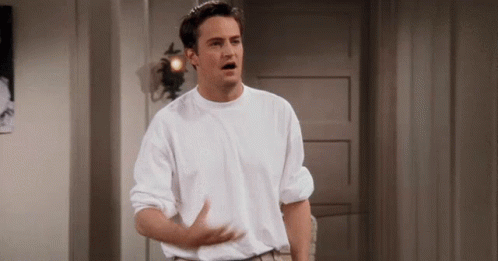 Man in White Shirt with Outstretched Arms in Hallway
