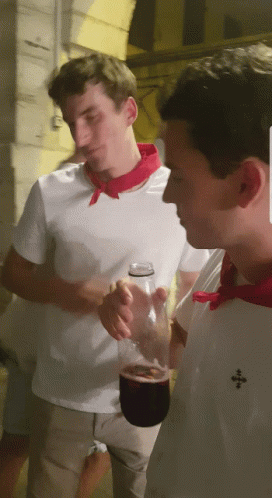 Man In White Shirt With Red Scarf Holding Wine GIF