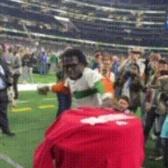 Man in White Shirt With Red Shirt on Back in Field