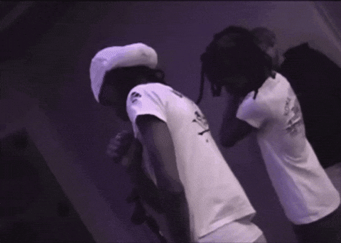 Man In White Shirt With Skull Next To Another Man GIF