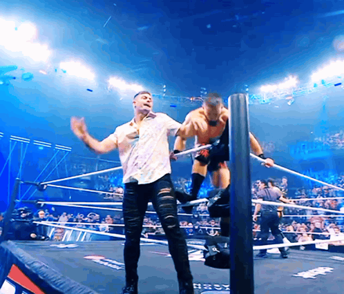 Man In White Shirt Wrestling In Ring Next To Man In Black Jeans GIF