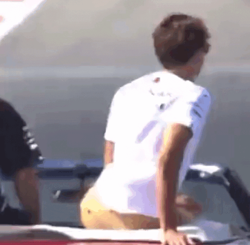 Man in White Shirt, Yellow Shorts by Car