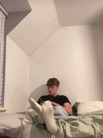 Man in White Socks Laying on Bed With Feet Up