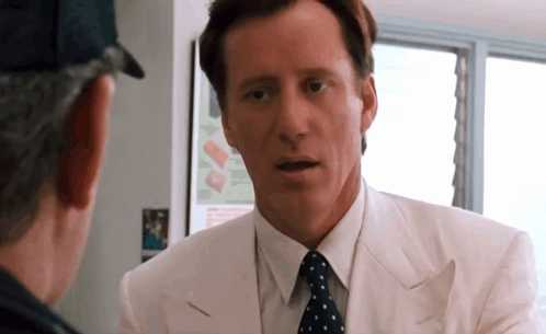 Man in White Suit and Polka Dot Tie Talking