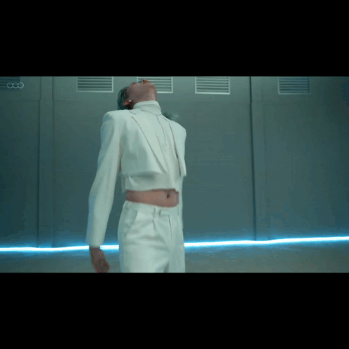Man In White Suit Beside Wall With Letter CC GIF