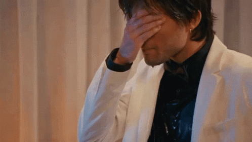 Man In White Suit Covering Face GIF