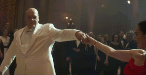 Man in White Suit Dancing with Woman in Red Dress