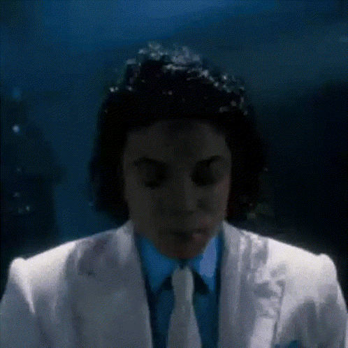 Man In White Suit Eyes Closed In Dark Room GIF