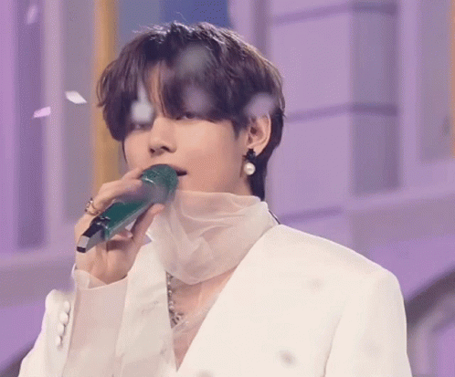 Man in White Suit Holding Green Microphone in Mouth