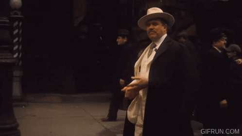 Man in White Suit Holding Orange Cigar Co. Sign
