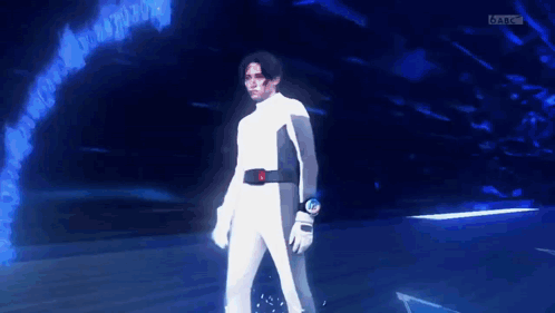 Man In White Suit In Dark Room With Blue Background GIF