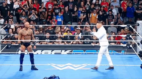 Man in White Suit in Wrestling Ring With Two Men