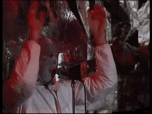Man in White Suit Singing into Microphone Holding Glass