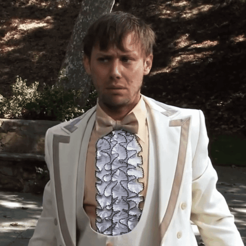 Man In White Suit With Ruffled Vest GIF