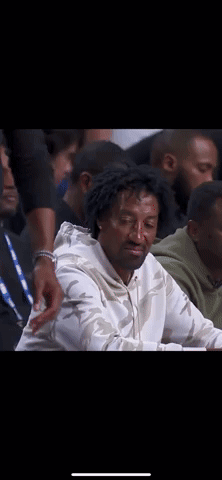 Man In White Sweatshirt Sitting In Crowd GIF