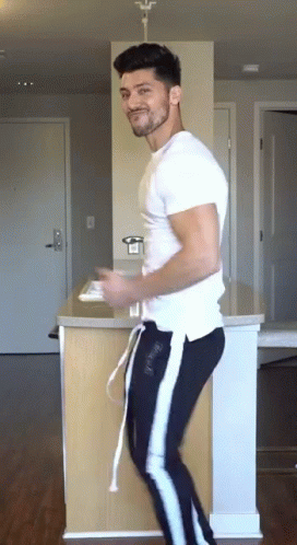 Man in White T-Shirt and Black Pants Dancing in Kitchen