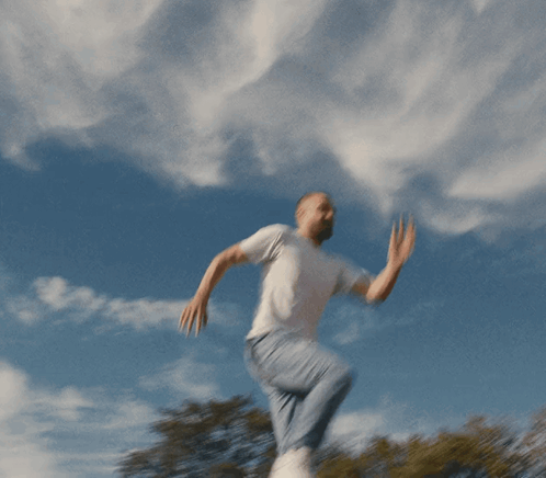 Man In White T-Shirt And Blue Jeans Jumping GIF