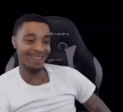 Man in White T-Shirt Smiling in Gaming Chair