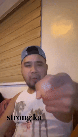 Man In White Tank Top And Blue Hat Pointing Saying Strong Ka GIF