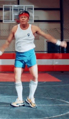 Man in White Tank Top and Blue Shorts Jumping