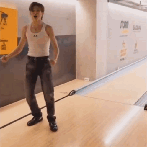 Man in White Tank Top and Jeans at Bowling Alley