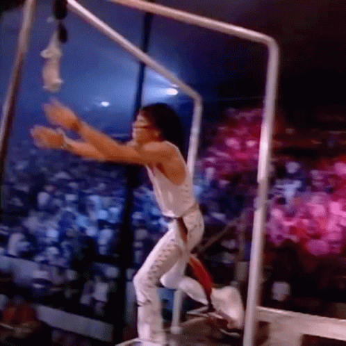 Man in White Tank Top Hanging from Bar