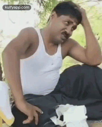 Man In White Tank Top Holding Head GIF