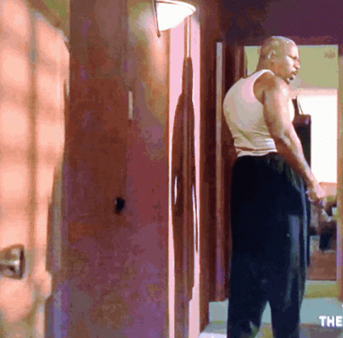 Man in White Tank Top in Hallway