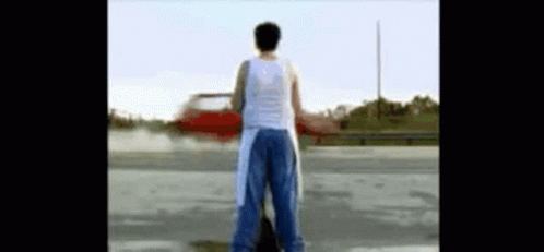 Man In White Tank Top In Parking Lot GIF