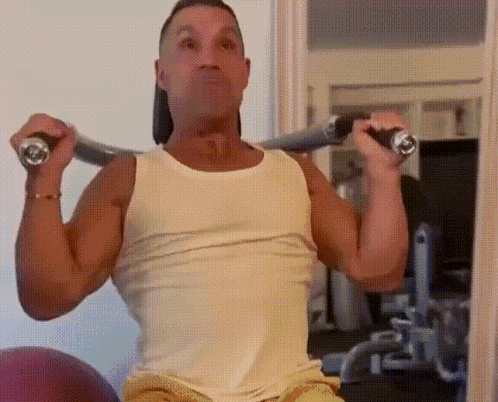 Man in White Tank Top Lifting Barbell Overhead